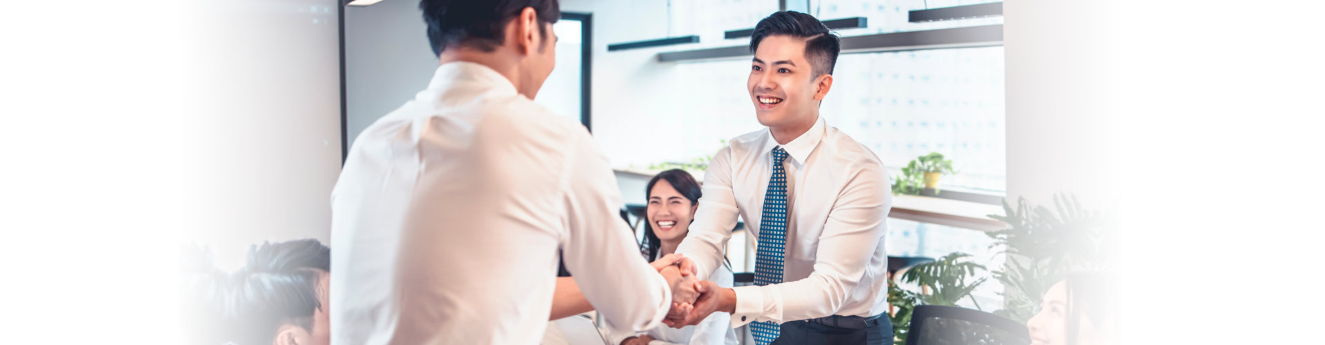 happy business people shaking hands in conference room